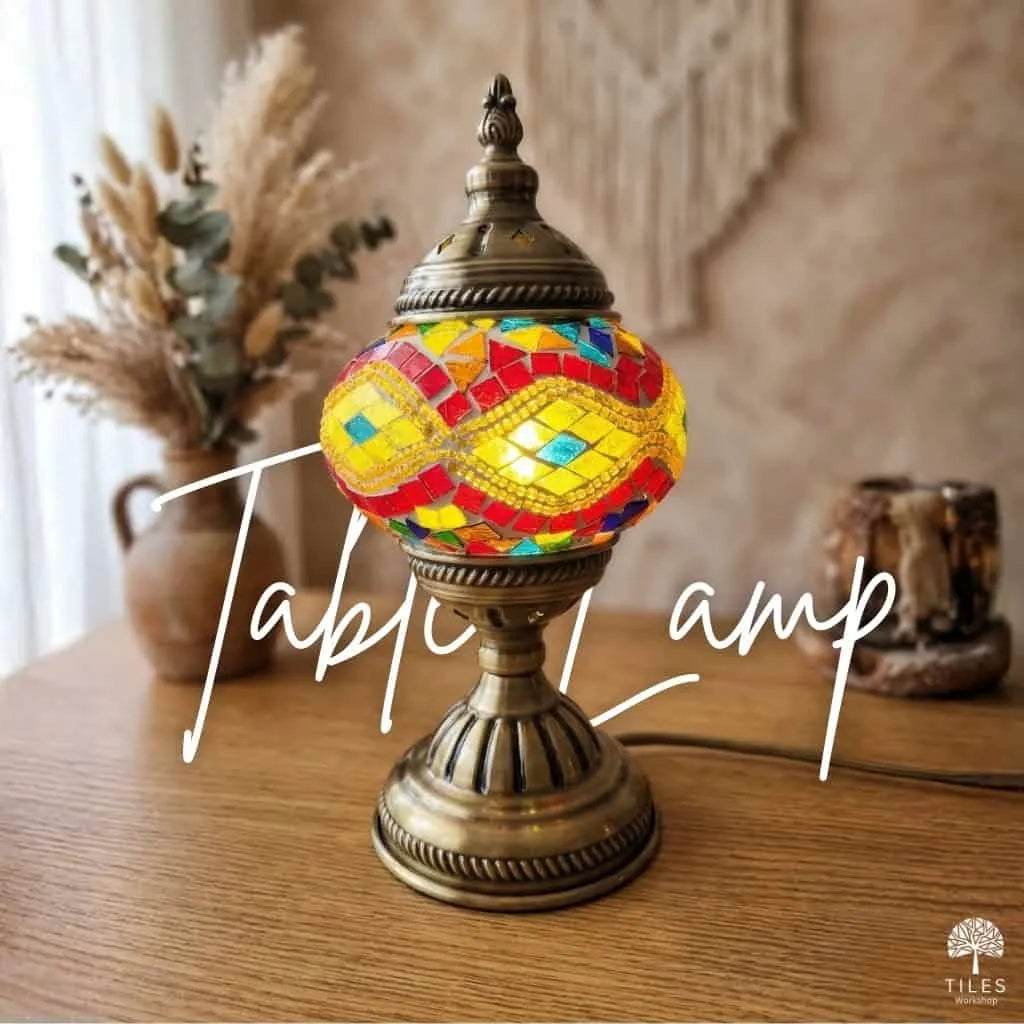 Colorful mosaic table lamp on a wooden surface with decorative elements in the background.